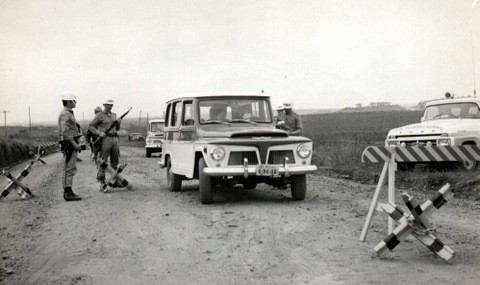 Homens parando um carro em uma barreria