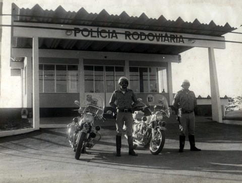 Dois oficiais postados ao lado de suas motocicletas
