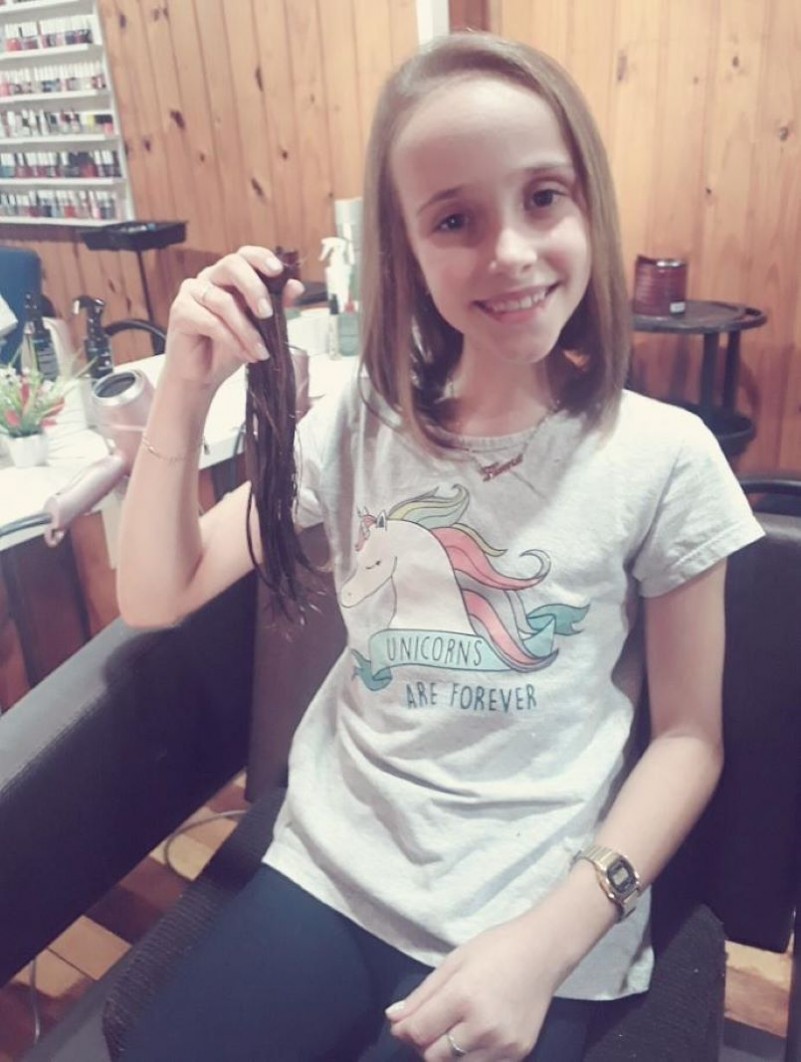 Pequena Flavia doando a mecha de seu cabelo