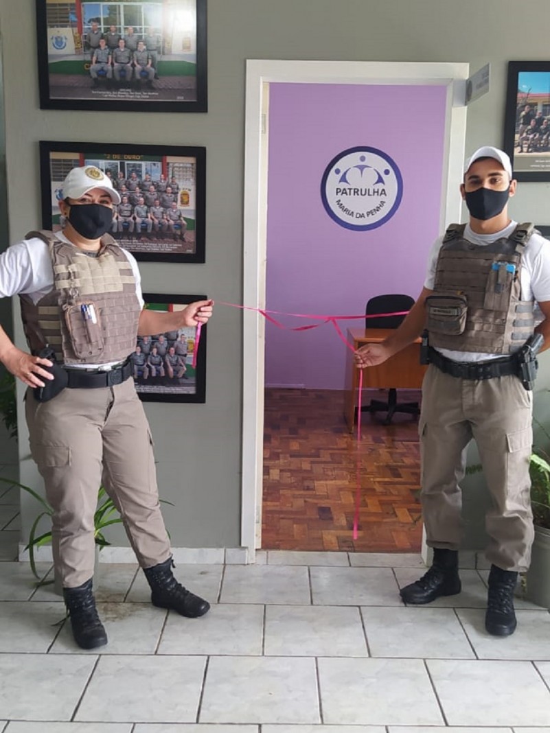 Policiais Militares desserando a fita de inauguração da sala.