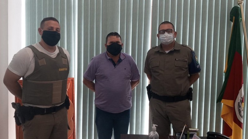 Policiais Militares fardados e o prefeito do município no centro.