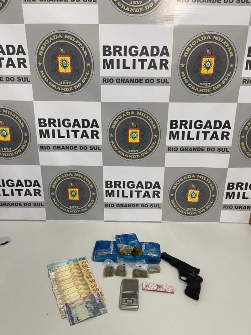 Na imagem aparecem dinheiro, droga, simulacro de revólver e balança de precisão.