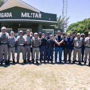 Grupo de brigadianos reunidos lado a lado em frente ao posto da BM