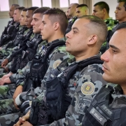 Militares da Policia de Choque sentados lado a lado, assistindo a uma palestra.