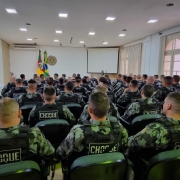 Sala de palestras cheia de Militares da Policia de Choque sentados lado a lado. 