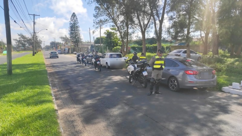 Foto mostra barreira policial, com dois veículos parados