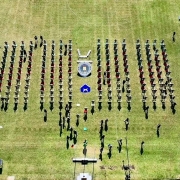 Imagem aérea, tirada de drone, mostra os novos soldados divididos em quatro grandes grupos em um gramado