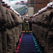 Foto mostra um corredor no meio de soldados que estão alinhados em duas filas, do lado direito e esquerdo