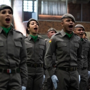 Imagem mostra soldados gritando a plenos pulmões durante um canto militar.