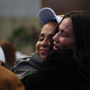 Foto mostra uma convidada chorando ao abraçar fortemente uma soldado nova
