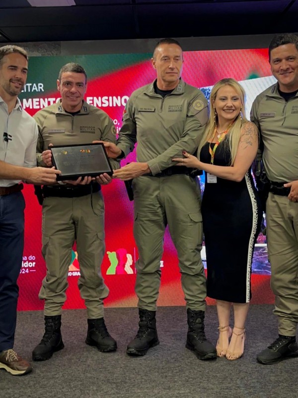 Imagem mostra oficiais da Brigada Militar segurando uma placa que simboliza o prêmio.