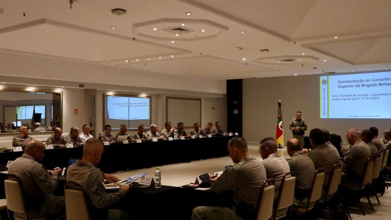 Militares sentados ouvindo apresentação durante reunião