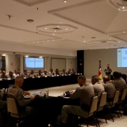 Militares sentados ouvindo apresentação durante reunião