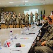 Imagem mostra os militares dispostos em círculo assistindo a explanação de um gruipo em pé no palco