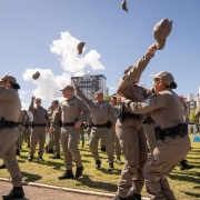 PMs abra&ccedil;am-se e festejam a formatura no campo do est&aacute;dio. 